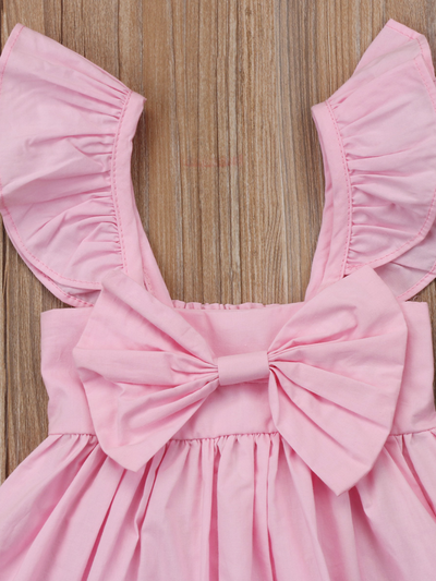Baby apron style dress has a ruffled adjustable straps and a stretchy bodice with a big bow