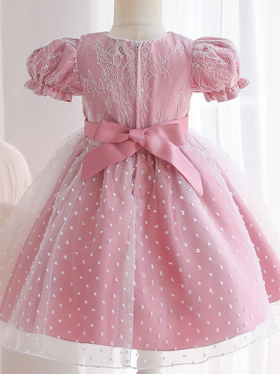 Baby dress has capped sleeves and embroidered tulle overlay bodice and swiss tulle overlay skirt, big bow accent at the back