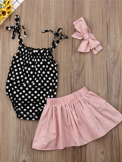 Baby set has a polka dot onesie with adjustable straps, comes with a pink skirt and matching headband
