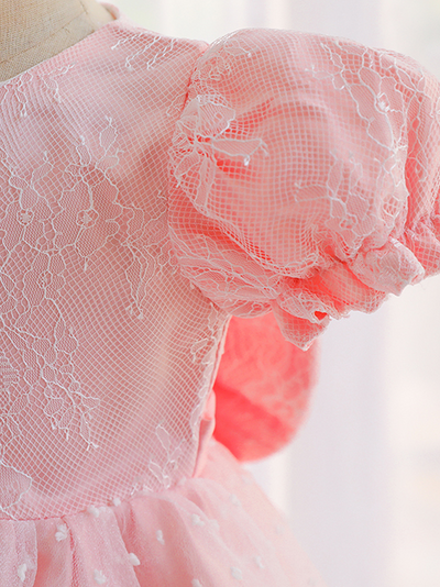 Baby dress has capped sleeves and embroidered tulle overlay bodice and swiss tulle overlay skirt, big bow accent at the back