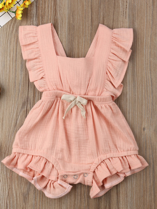 Baby bohemian Overall style romper onesie that ties in the back and has a drawstring at the waist. Little ruffled adorn the shoulder and short hem pink
