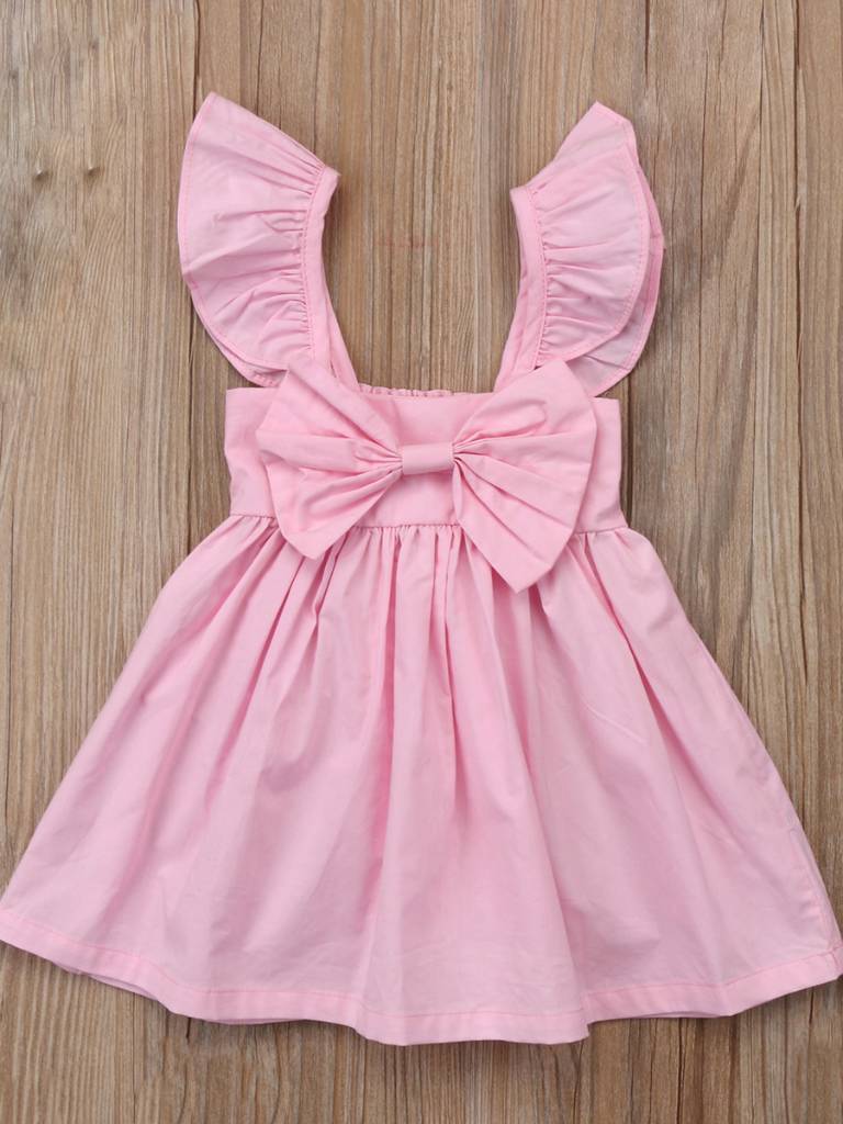 Baby apron style dress has a ruffled adjustable straps and a stretchy bodice with a big bow