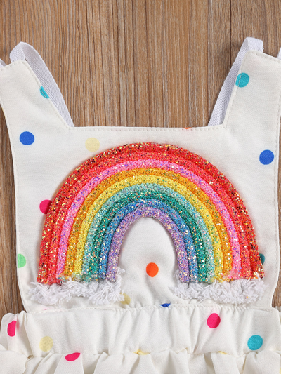 Baby white dress has a colorful polka dot print and rainbow applique pullover style ties at the back