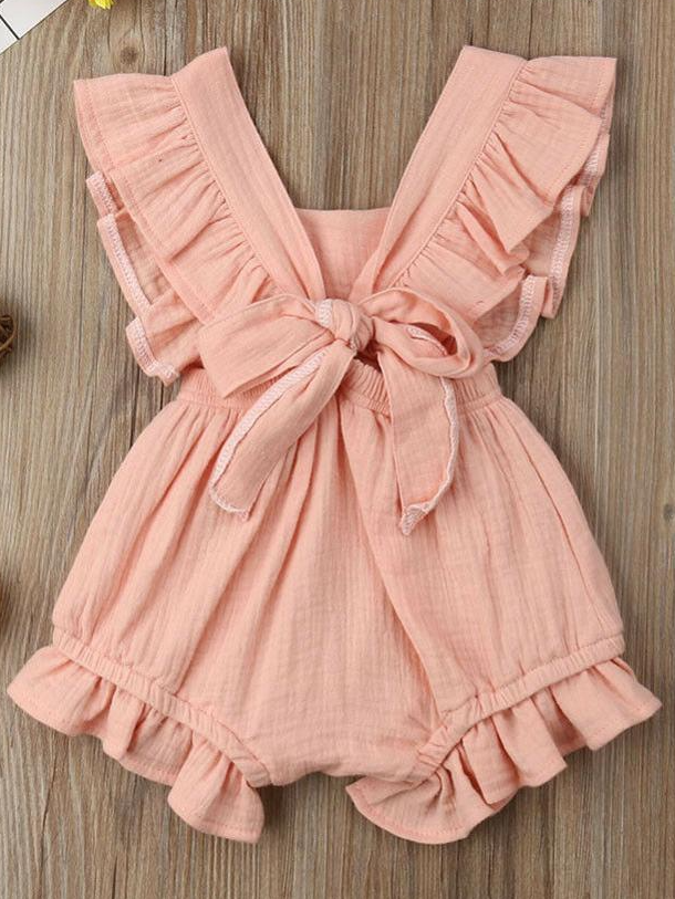 Baby bohemian Overall style romper onesie that ties in the back and has a drawstring at the waist. Little ruffled adorn the shoulder and short hem pink