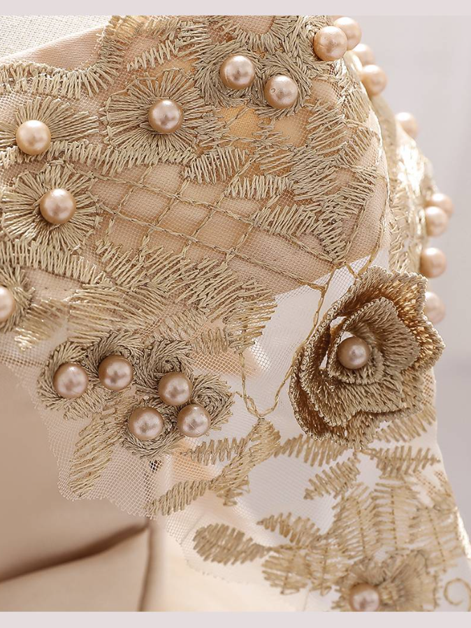 Baby dress has a satin embroidered bodice with pearl details and capped sleeves, a bow belt at the waist, and a tulle skirt with flower applique