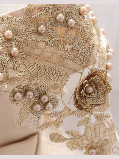 Baby dress has a satin embroidered bodice with pearl details and capped sleeves, a bow belt at the waist, and a tulle skirt with flower applique