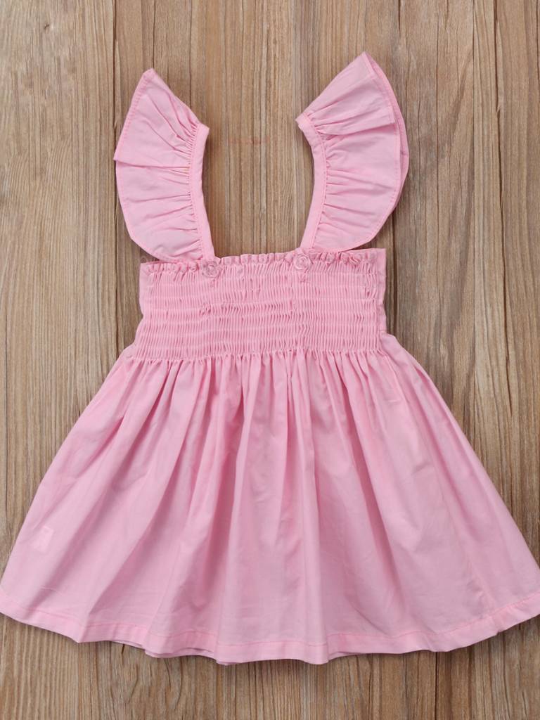 Baby apron style dress has a ruffled adjustable straps and a stretchy bodice with a big bow