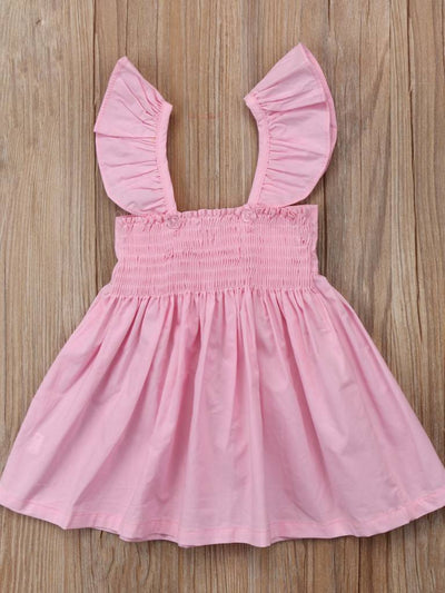 Baby apron style dress has a ruffled adjustable straps and a stretchy bodice with a big bow