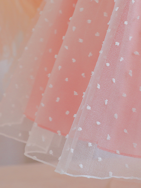 Baby dress has capped sleeves and embroidered tulle overlay bodice and swiss tulle overlay skirt, big bow accent at the back