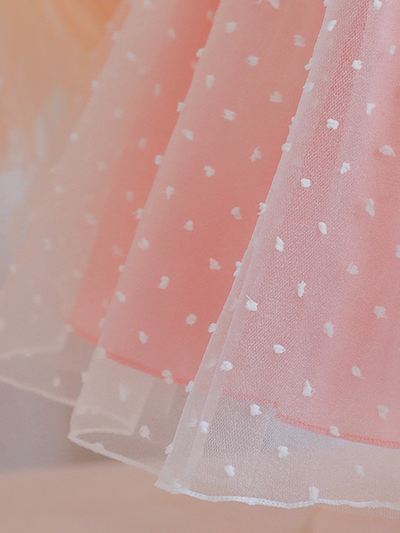 Baby dress has capped sleeves and embroidered tulle overlay bodice and swiss tulle overlay skirt, big bow accent at the back