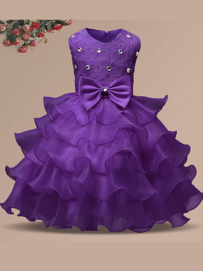 Baby princess dress has a floral lace bodice with rhinestone details, a bow belt at the waist, and a multi-layered tulle skirt