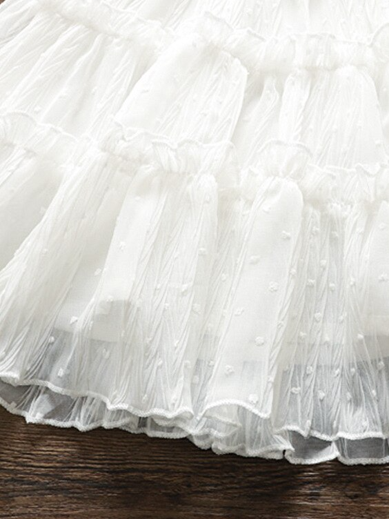 Baby swiss tulle dress has delicate ruffles and a little bow at the front