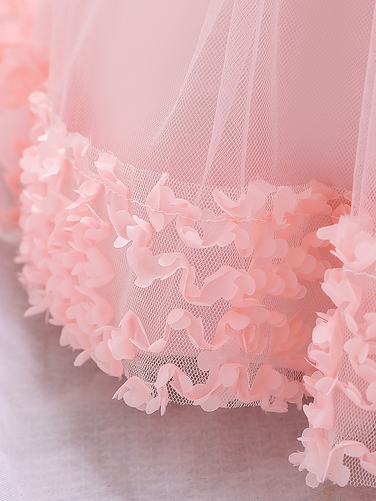 Baby dress has a floral bodice, a tulle skirt with floral hem, and a gold sequin belt with bow at the front and back