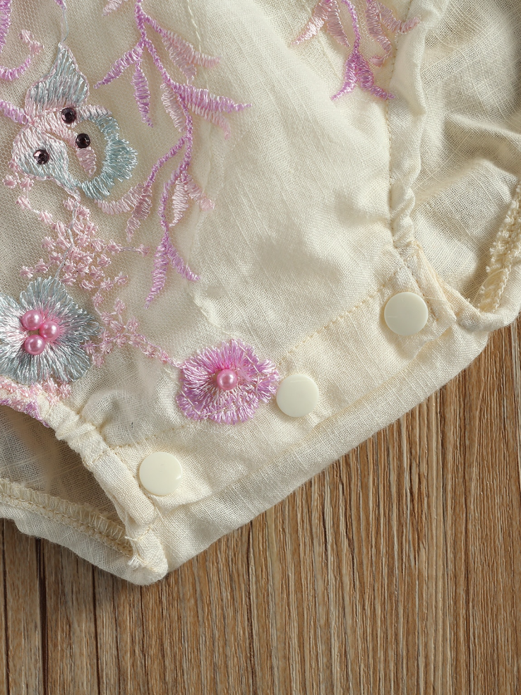 Baby overall style onesie with delicate flower embroidered, lace ruffles on the bum that ties in the back, tulle, and lace ruffled shoulders