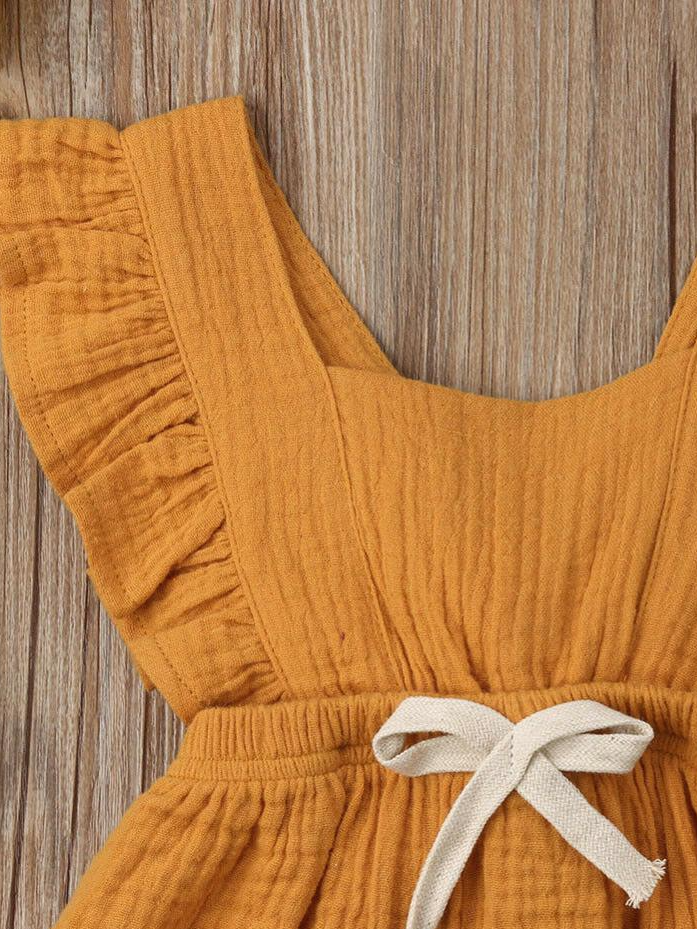 Baby bohemian Overall style romper onesie that ties in the back and has a drawstring at the waist. Little ruffled adorn the shoulder and short hem burgundy