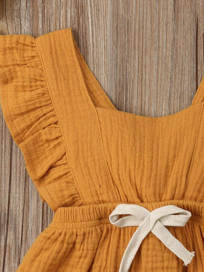 Baby bohemian Overall style romper onesie that ties in the back and has a drawstring at the waist. Little ruffled adorn the shoulder and short hem burgundy