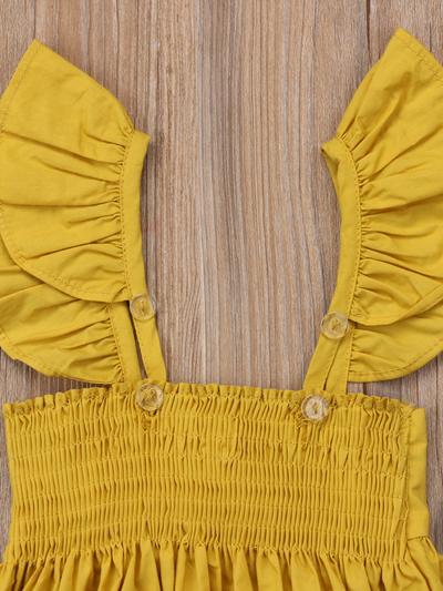 Baby apron style dress has a ruffled adjustable straps and a stretchy bodice with a big bow