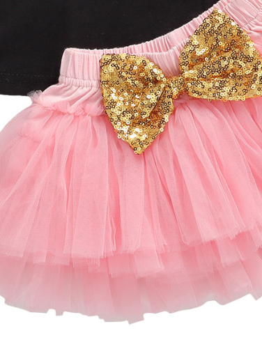 Baby set features a black top with a gold "One" print and a pink tutu skirt with a sequin bow at the waist. Comes with a matching sequin headband