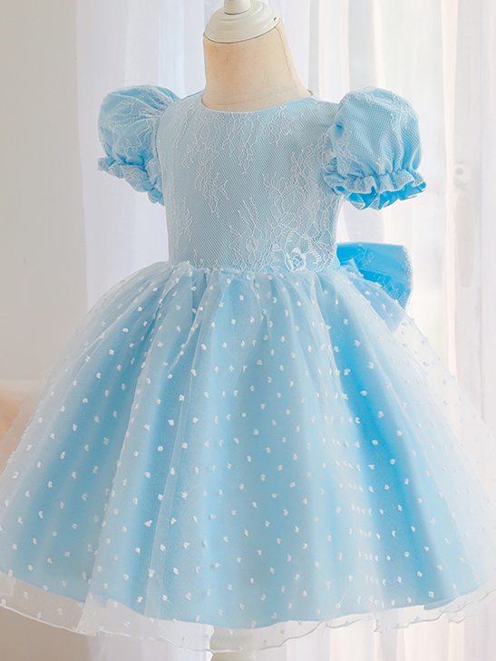 Baby dress has capped sleeves and embroidered tulle overlay bodice and swiss tulle overlay skirt, big bow accent at the back