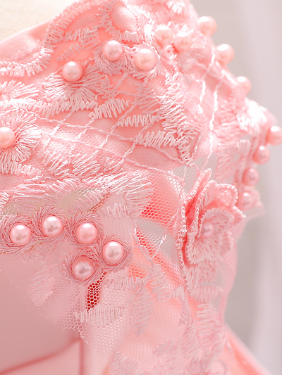 Baby dress has a satin embroidered bodice with pearl details and capped sleeves, a bow belt at the waist, and a tulle skirt with flower applique