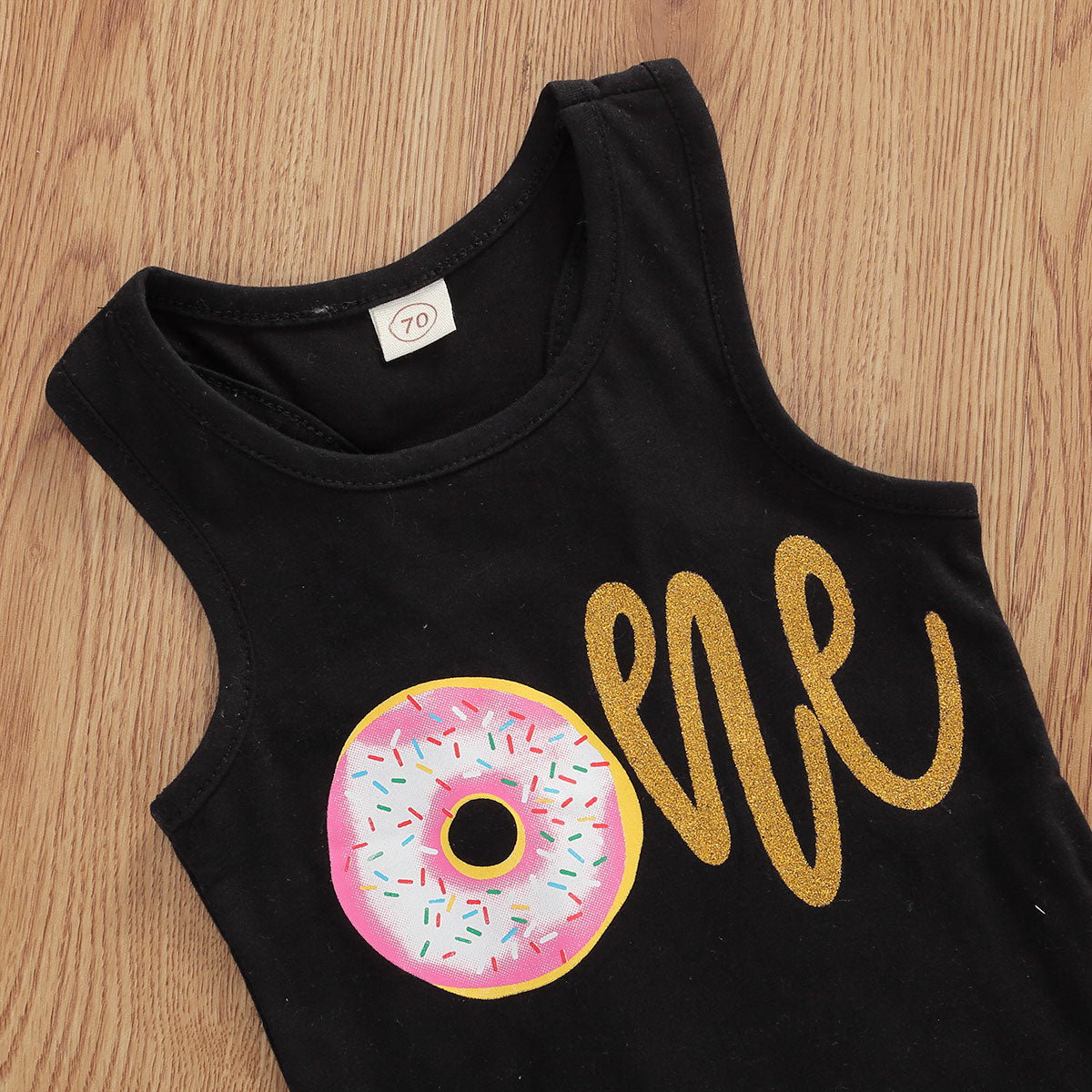 Baby set features a black top with a gold "One" print and a pink tutu skirt with a sequin bow at the waist. Comes with a matching sequin headband