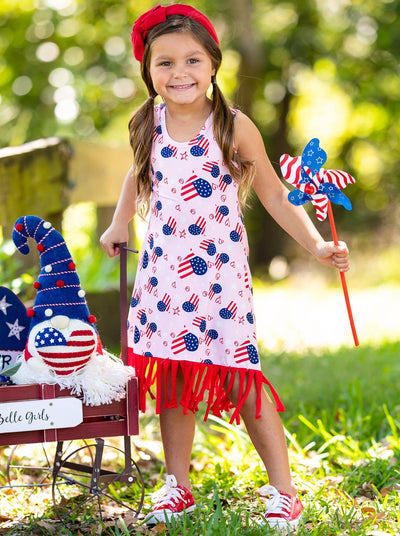 Girls pink dress features an Americana print with fun fringes at the hem