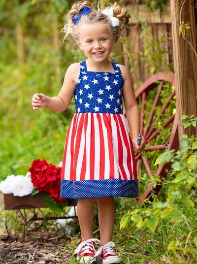 girls dress features a blue bodice with white stars, a red/white striped skirt, and a starred hem