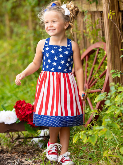 girls dress features a blue bodice with white stars, a red/white striped skirt, and a starred hem