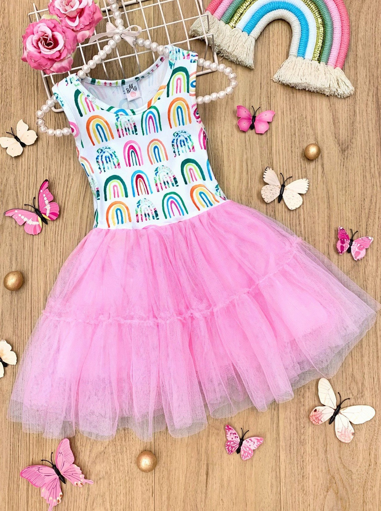 Girls dress has a white bodice with rainbow prints and a full pink tutu skirt