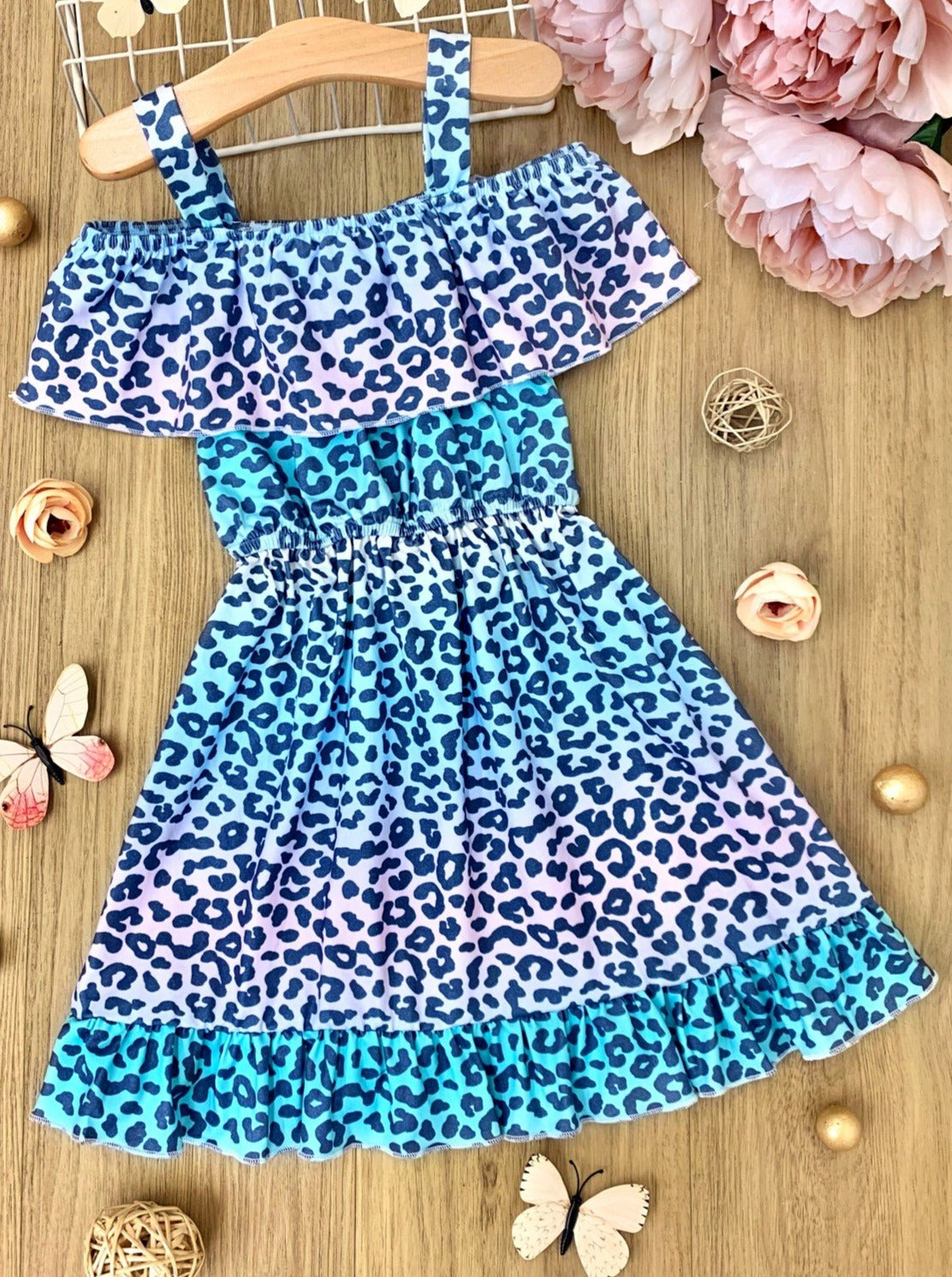Girls dress features a cold-shoulder 360-degree ruffle bib, cinched waist, ruffle hem, and pastel ombre leopard print pattern
