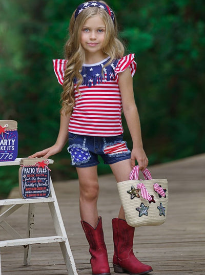 Girls 4th of July set features an American flag print flutter sleeve top with fringe neckline and patched denim shorts with a sash