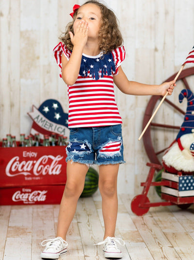 Girls 4th of July set features an American flag print flutter sleeve top with fringe neckline and patched denim shorts with a sash