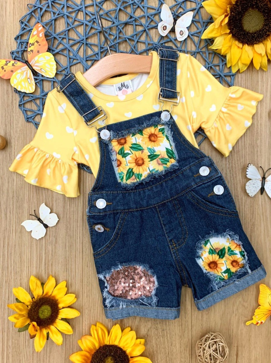 Girls Summer set features a yellow ruffle sleeve top with white polka dots and denim overall shorts with sunflower print and sequin mesh patches - 2T-10Y