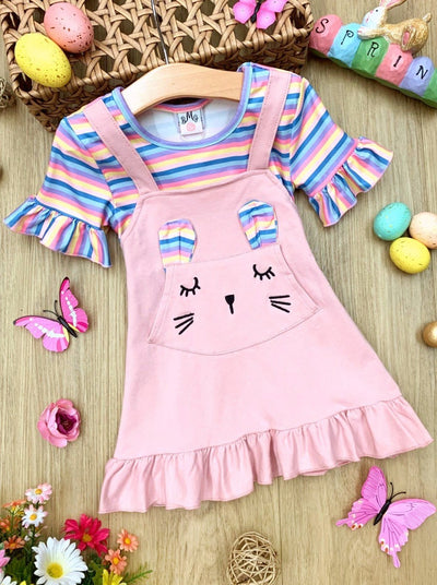 Girls Easter Dress features a striped top with ruffled short sleeves and an overall skirt with a front kangaroo pocket and bunny face and bunny ears- pink 2T to 10Y