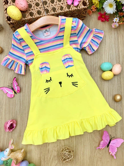 Girls Easter Dress features a striped top with ruffled short sleeves and an overall skirt with a front kangaroo pocket and bunny face and bunny ears- pink 2T to 10Y