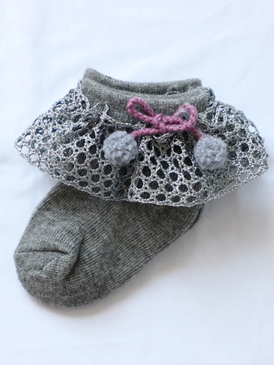 Baby socks with crochet and pompom details