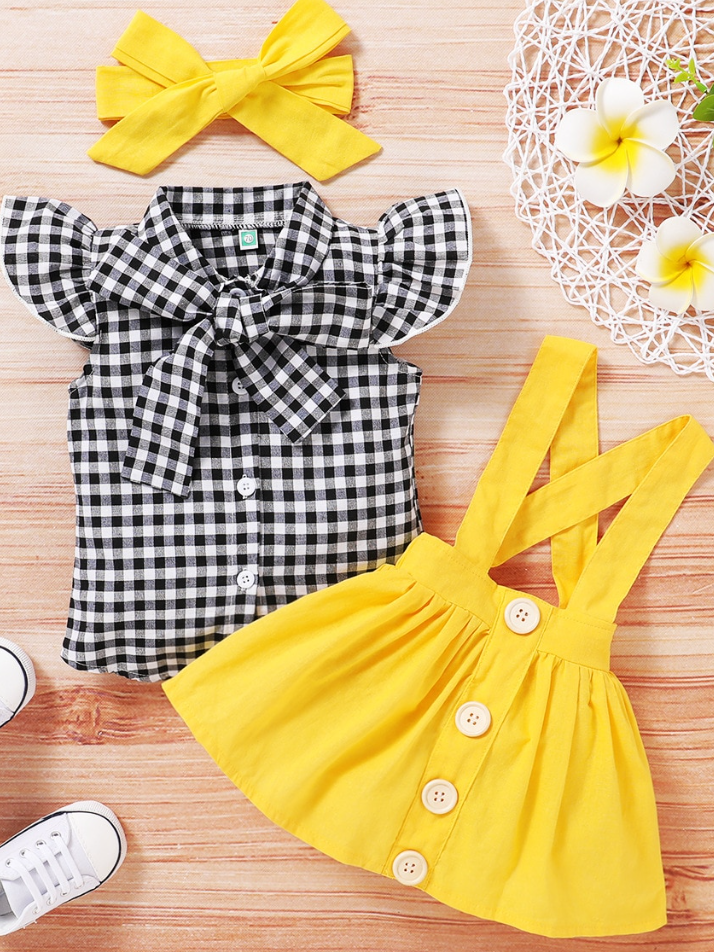 Baby set features a plaid top with front buttons and bow at the color, a skirt with cute suspenders, and a matching headband