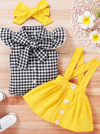 Baby set features a plaid top with front buttons and bow at the color, a skirt with cute suspenders, and a matching headband