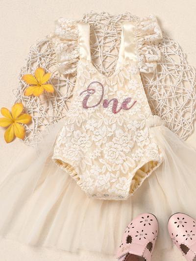 Baby lace overall onesie that ties at the back with tulle train, little ruffles at the shoulder, and a gold "One" printed on the bodice