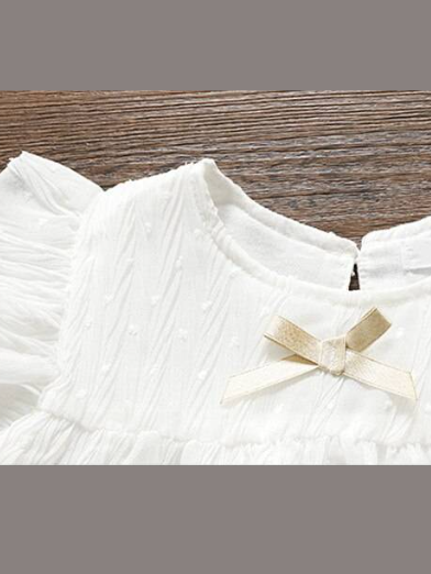 Baby swiss tulle dress has delicate ruffles and a little bow at the front