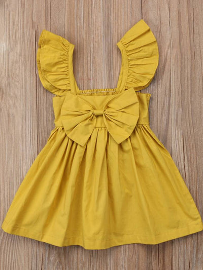 Baby apron style dress has a ruffled adjustable straps and a stretchy bodice with a big bow