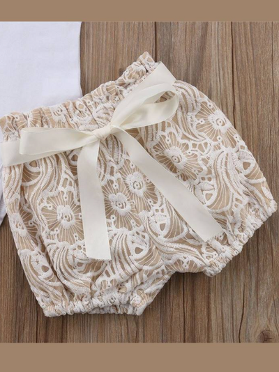 Baby set features a short-sleeved onesie with a crochet ruffle at the shoulder and embroidered shorts with a sash