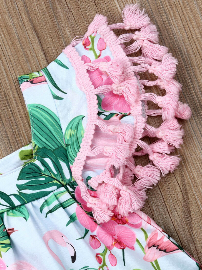 Baby apron style dress has a flamingo and tropical leaf print, a cute tasseled hem at the ruffled shoulders add a little extra-extra