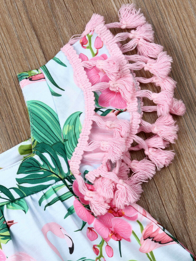 Baby apron style dress has a flamingo and tropical leaf print, a cute tasseled hem at the ruffled shoulders add a little extra-extra