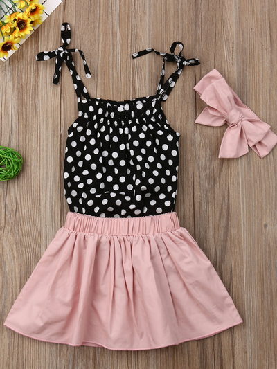 Baby set has a polka dot onesie with adjustable straps, comes with a pink skirt and matching headband