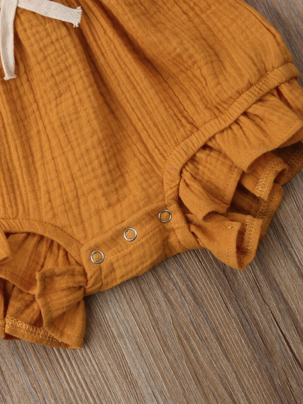 Baby bohemian Overall style romper onesie that ties in the back and has a drawstring at the waist. Little ruffled adorn the shoulder and short hem