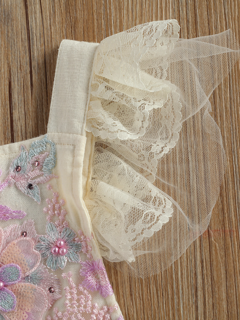 Baby overall style onesie with delicate flower embroidered, lace ruffles on the bum that ties in the back, tulle, and lace ruffled shoulders